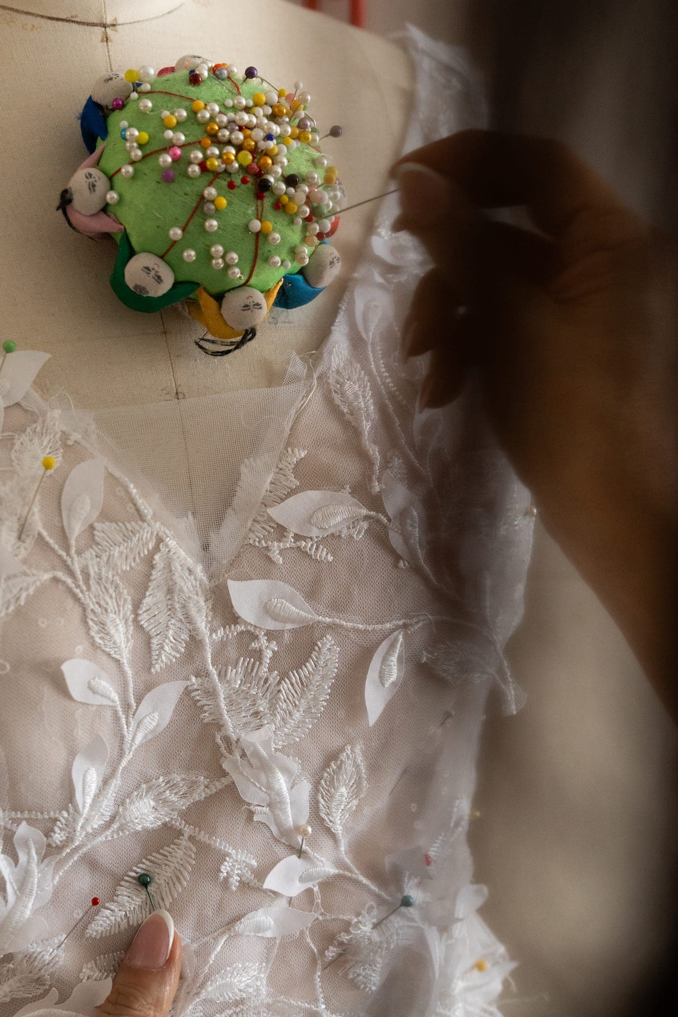 Hand-finishing lace details on a debutante gown