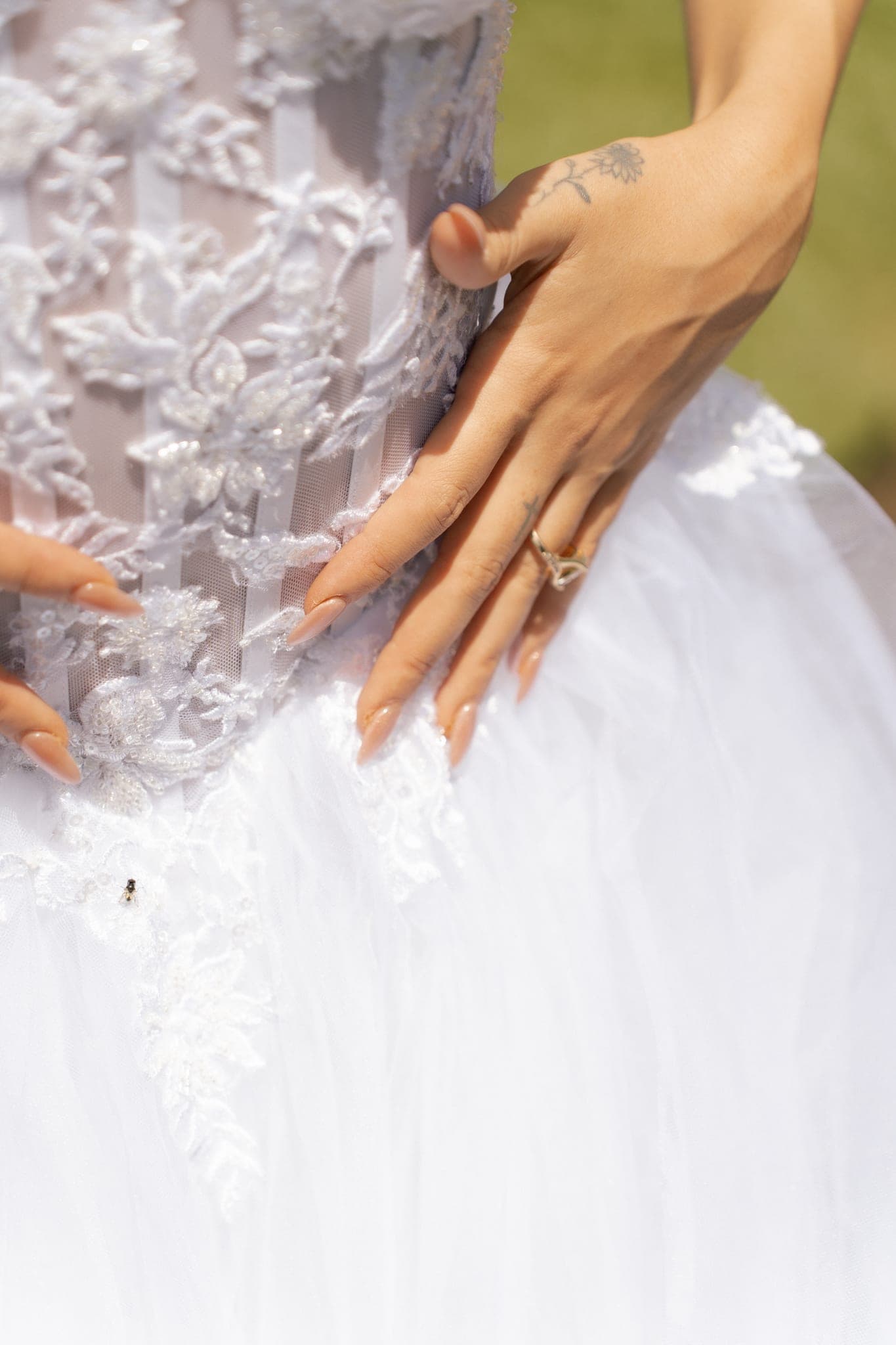A hand on the beading, close enough to count the pearls